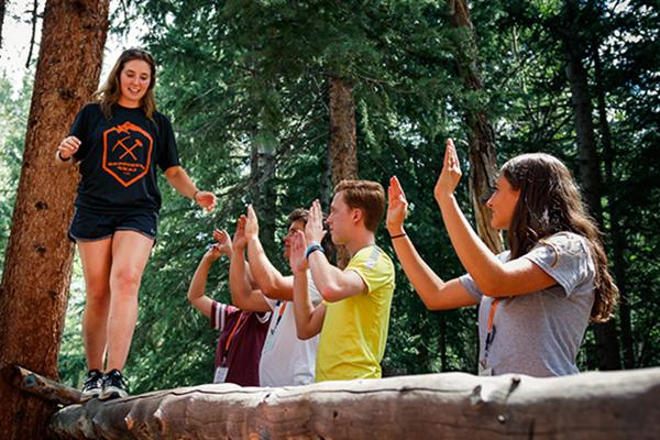 student walking across log